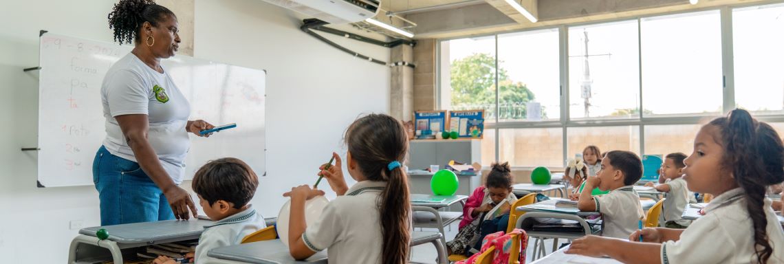 Profesora enseñando a estudiantes dentro del aula de clase Profesora enseñando a estudiantes dentro del aula de clase