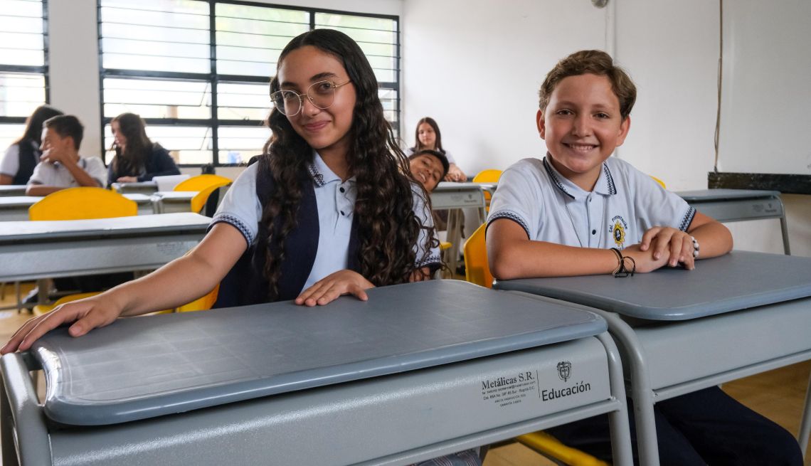 Dos estudiantes, niña y niño, dentro del aula de clase Dos estudiantes, niña y niño, dentro del aula de clase