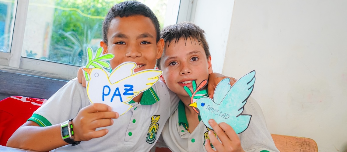 Fotos de niños en convivencia abrazados con un mensaje de paz